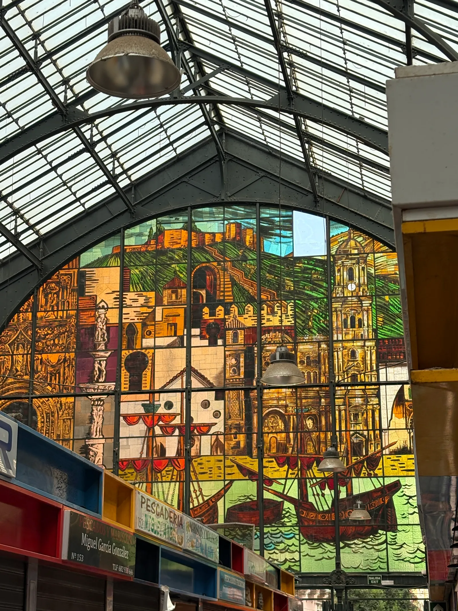 The interior view of the stained glass wall of Atarazanas market in Malaga depicting boats, horses and fields.