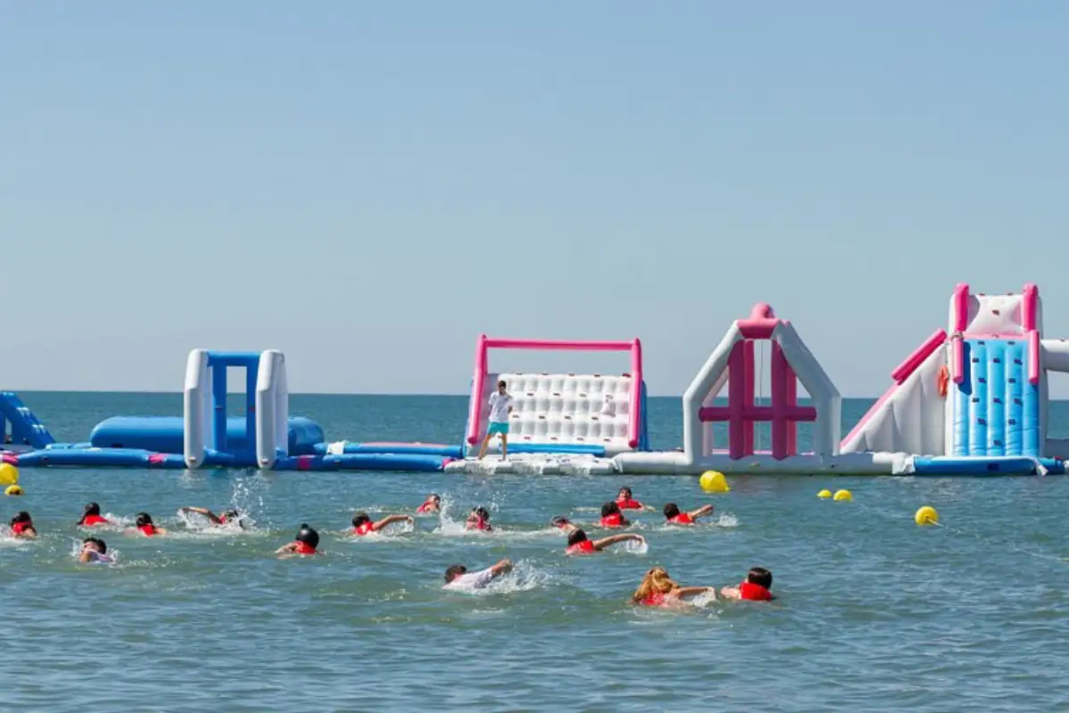 Children playing on WaterFun inflatable floating playground off Malaga beach
