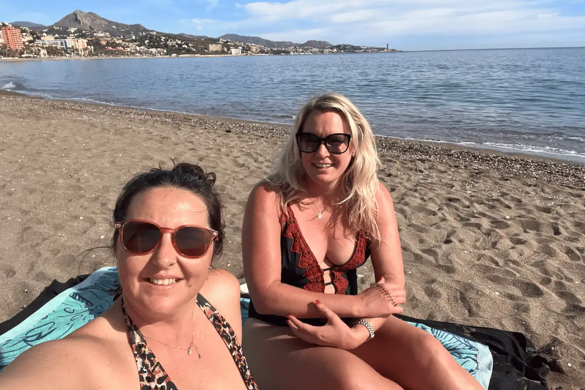 Two women sunbathing on the beach in Malaga