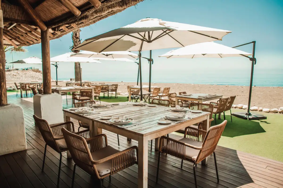White-tablecloth terrace at Candado Beach restaurant beside the marina Málaga