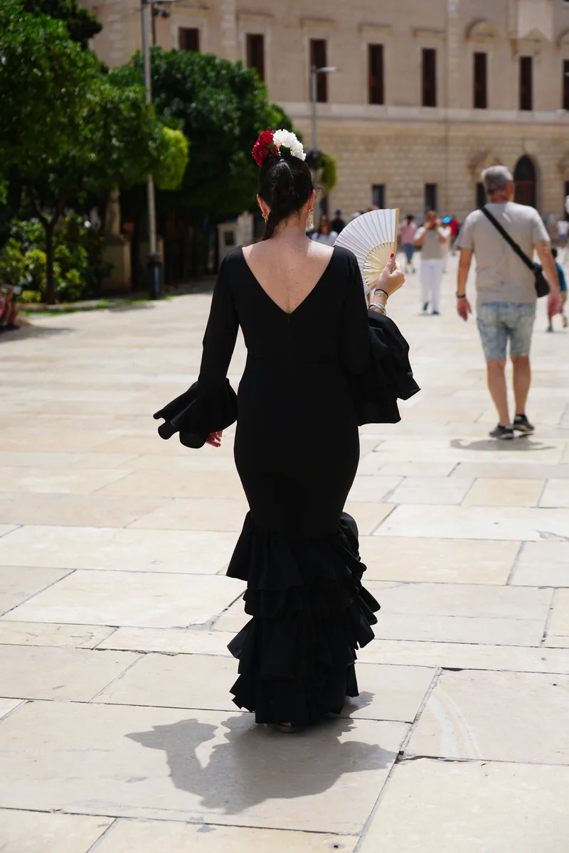 A black flamenco dress and fan seen from behind