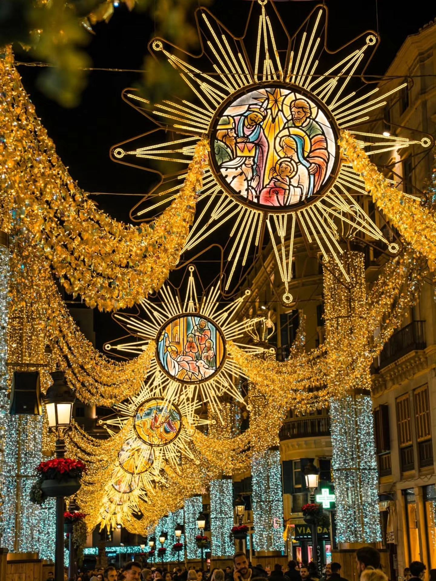 Golden nativity star Christmas lights decorating Calle Larios in Málaga at night