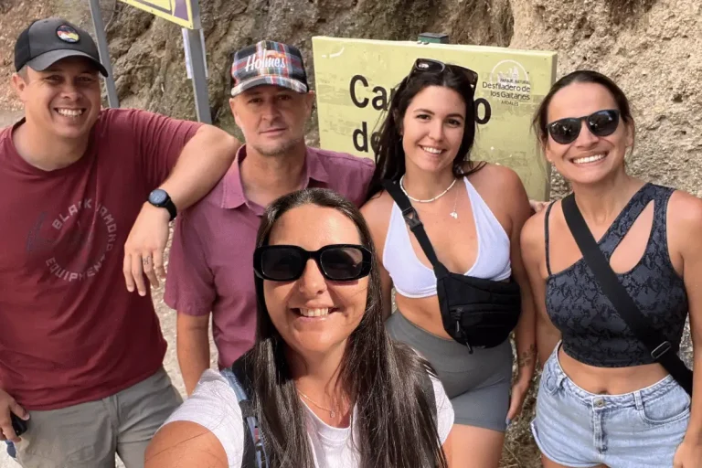 Group of friends posing at the Caminito del Rey entrance sign at the gorge
