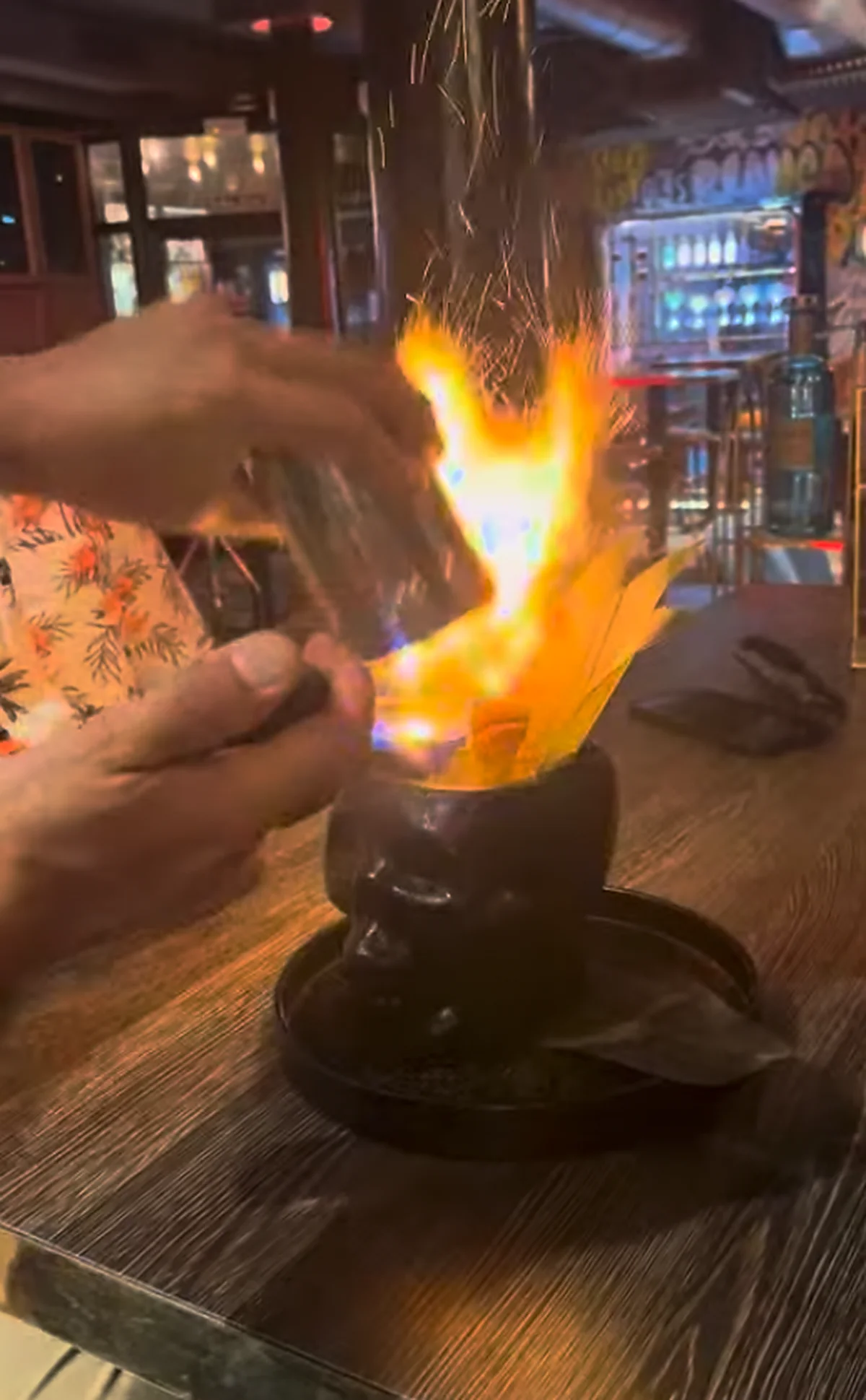 The Walking Dead cocktail being set alight at Chester & Punk, flames and sparks rising out of a black skull mug as the bartender pours