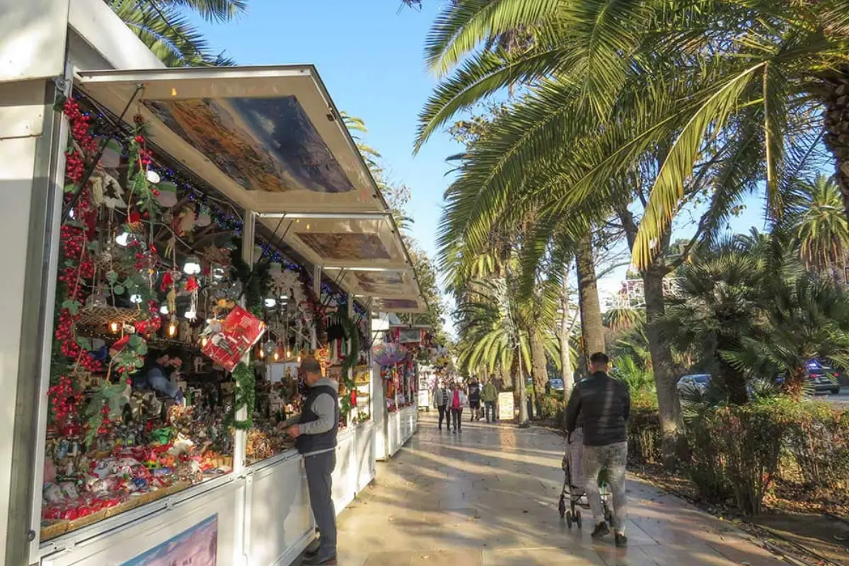 Christmas market stalls lining the palm-lined Paseo del Parque promenade in Malaga