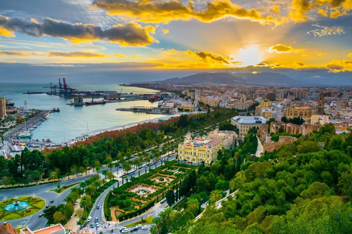 Aerial sunset view over Málaga city showing the park, cathedral and port
