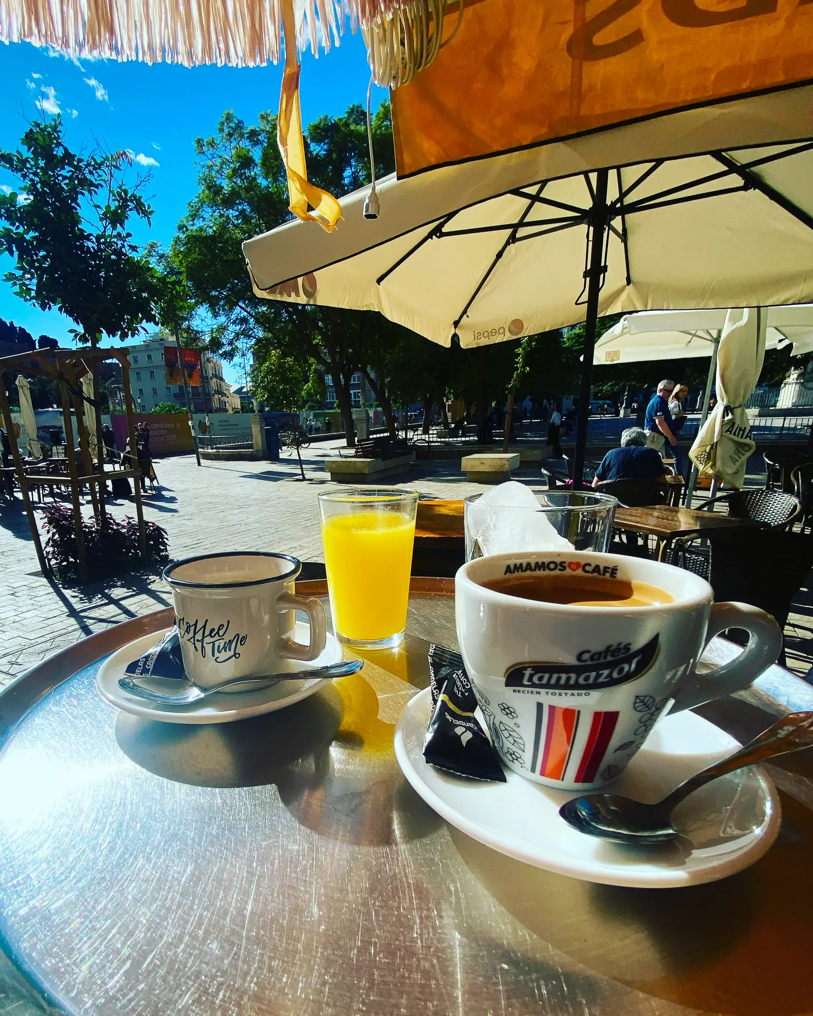 Coffee and fresh juice on a table on a plaza terrace in Málaga