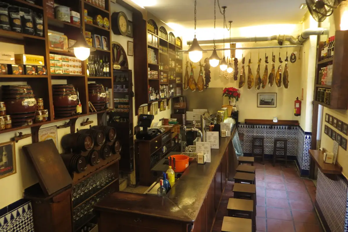 Cured hams and sherry barrels in a traditional Málaga colmado