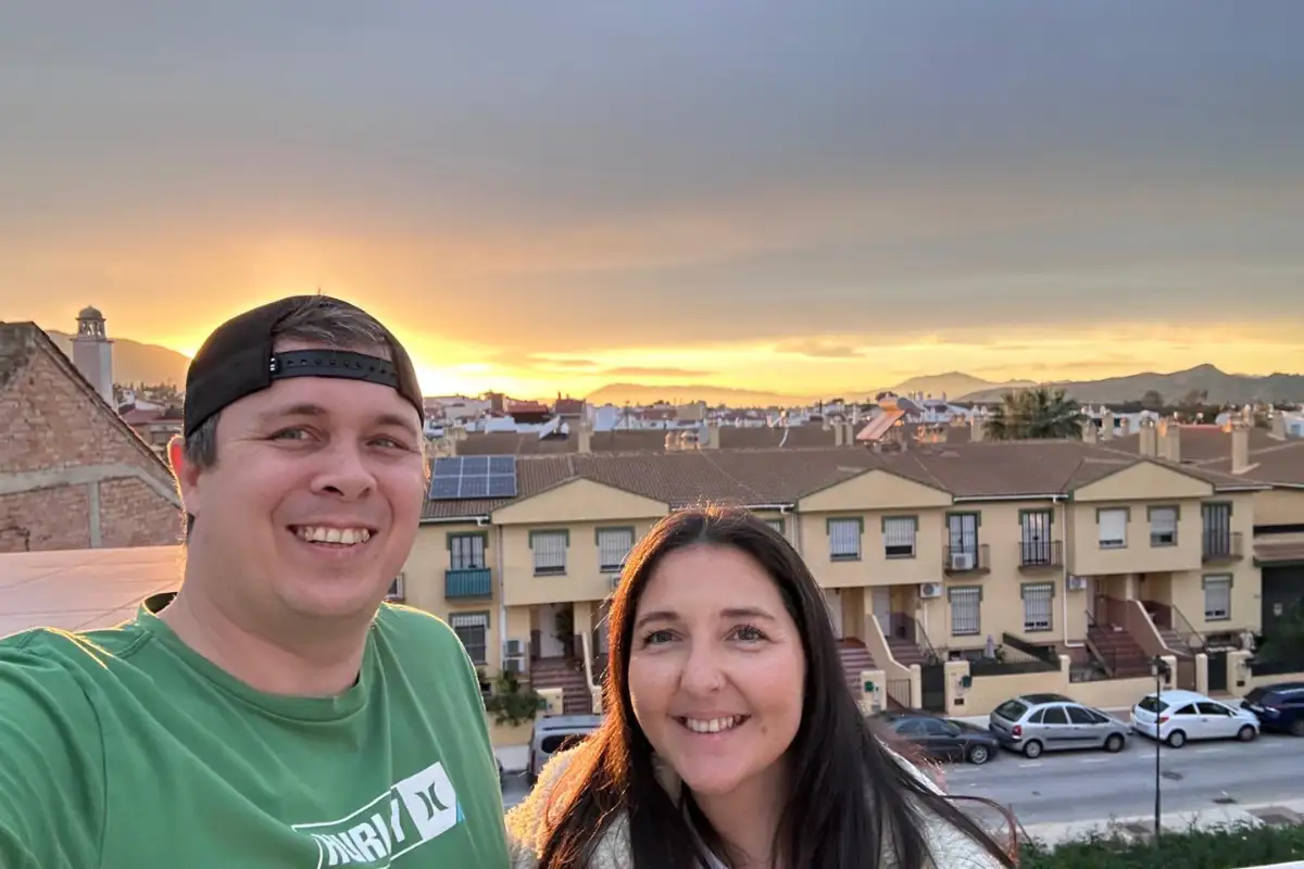 Heidi and Jethro at sunset, the sky going orange over the rooftops and the mountains behind Málaga