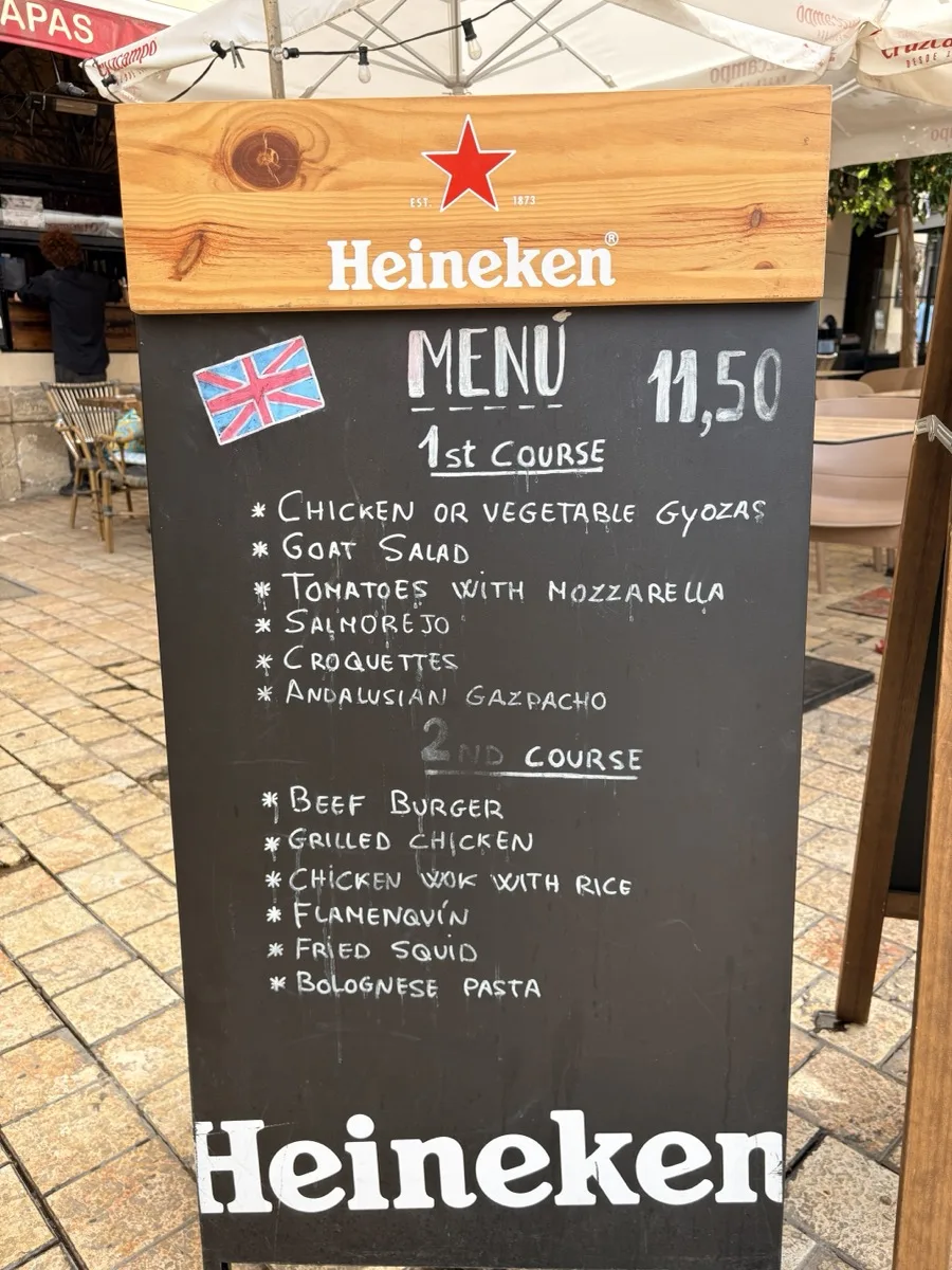 The menu board outside El Carmen Bar in Málaga, listing courses in English for €11.50