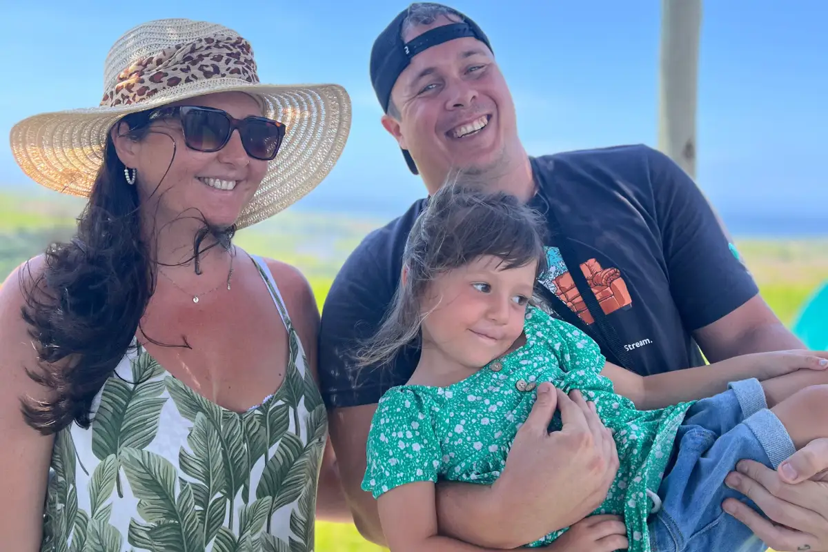 Family with a young child smiling outdoors with sea views in Málaga