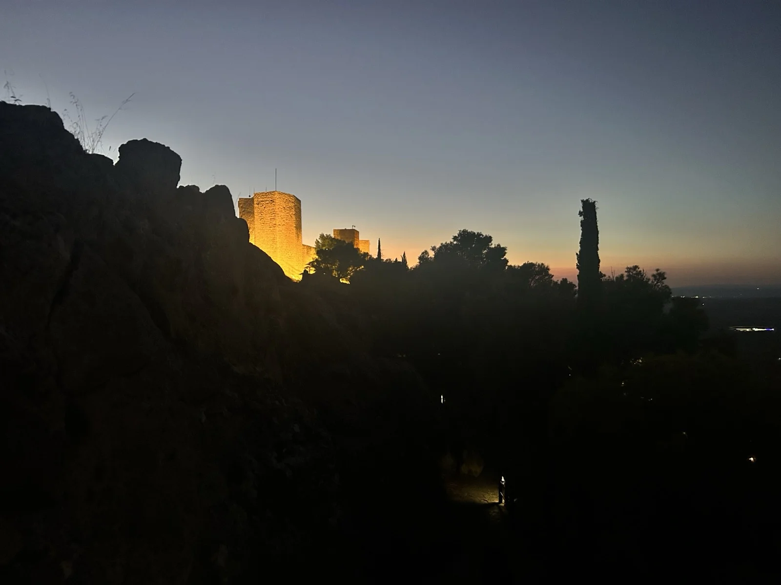 Castillo de Gibralfaro's walls lit up against a purple dusk sky