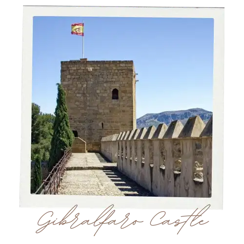 Stone battlements of Gibralfaro Castle with Malaga city and the Mediterranean below