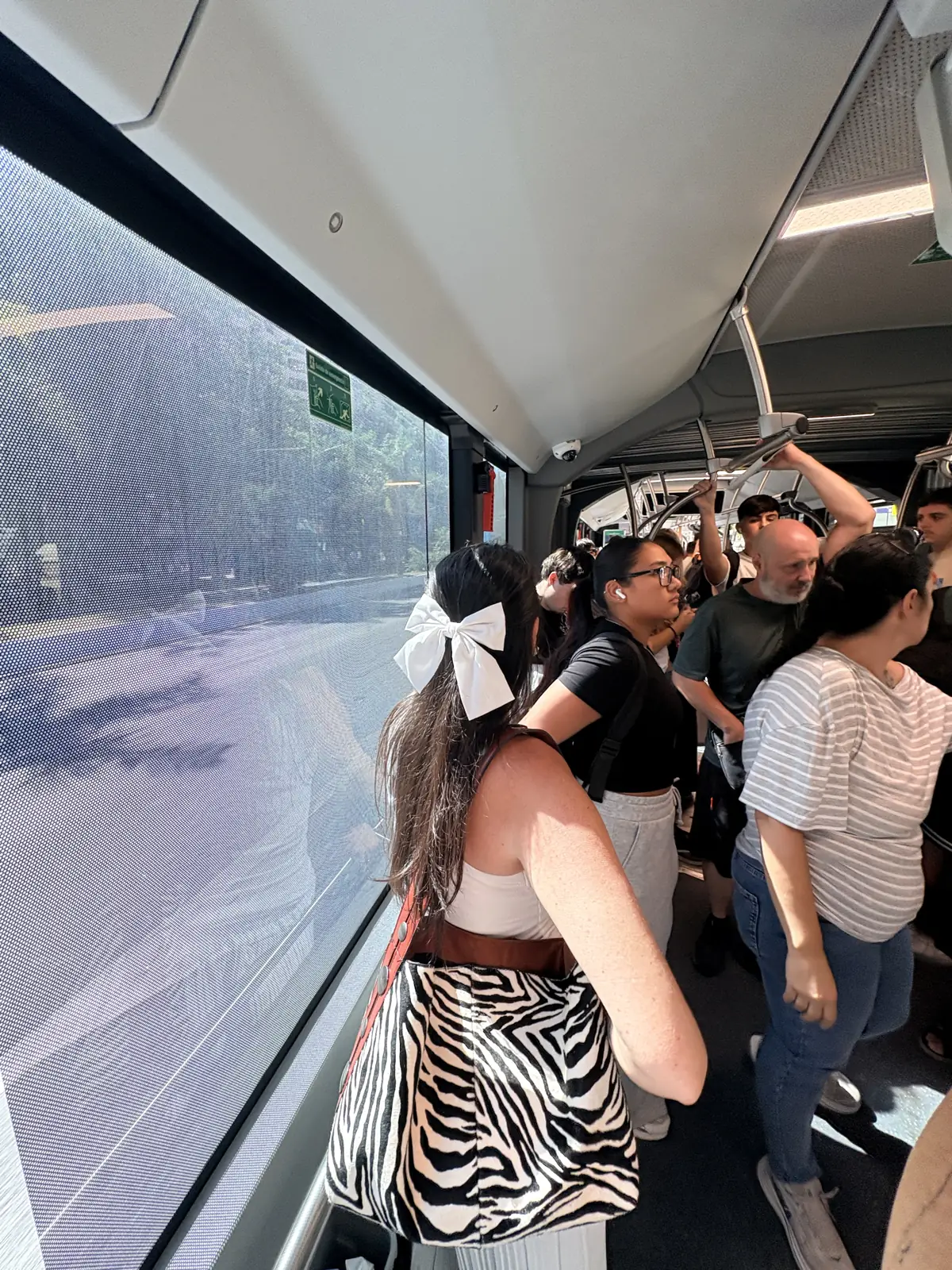 Heidi standing by the window on a packed EMT bus in Málaga