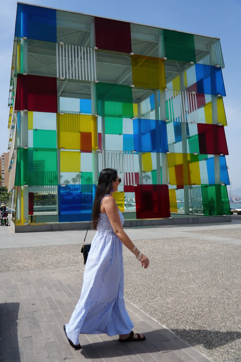 Heidi walking past the multicoloured glass Cube of Centre Pompidou Malaga