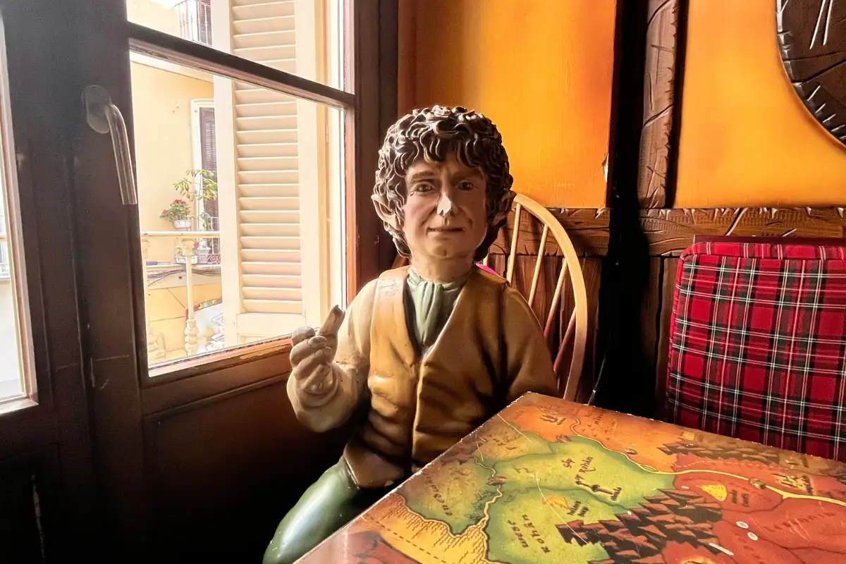 Hobbit figurine seated at a window table in a quirky themed bar in Málaga