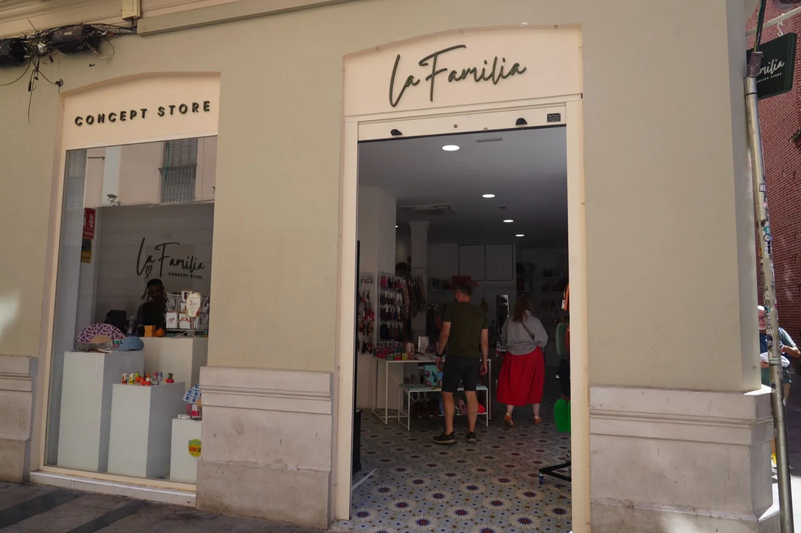 La Familia Concept Store entrance in Malaga, with the shop's script logo above the open doorway and the tiled floor visible inside