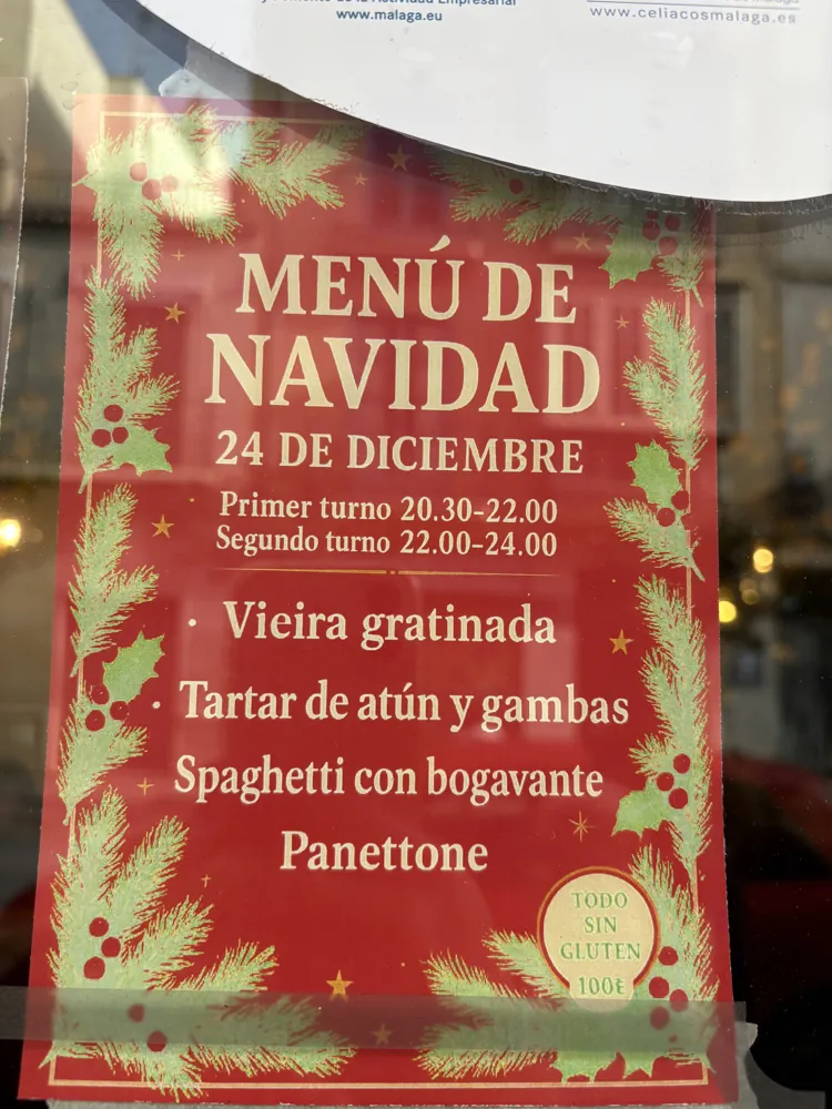 Christmas menu sign in a Malaga restaurant window, listing the 24 December set menu