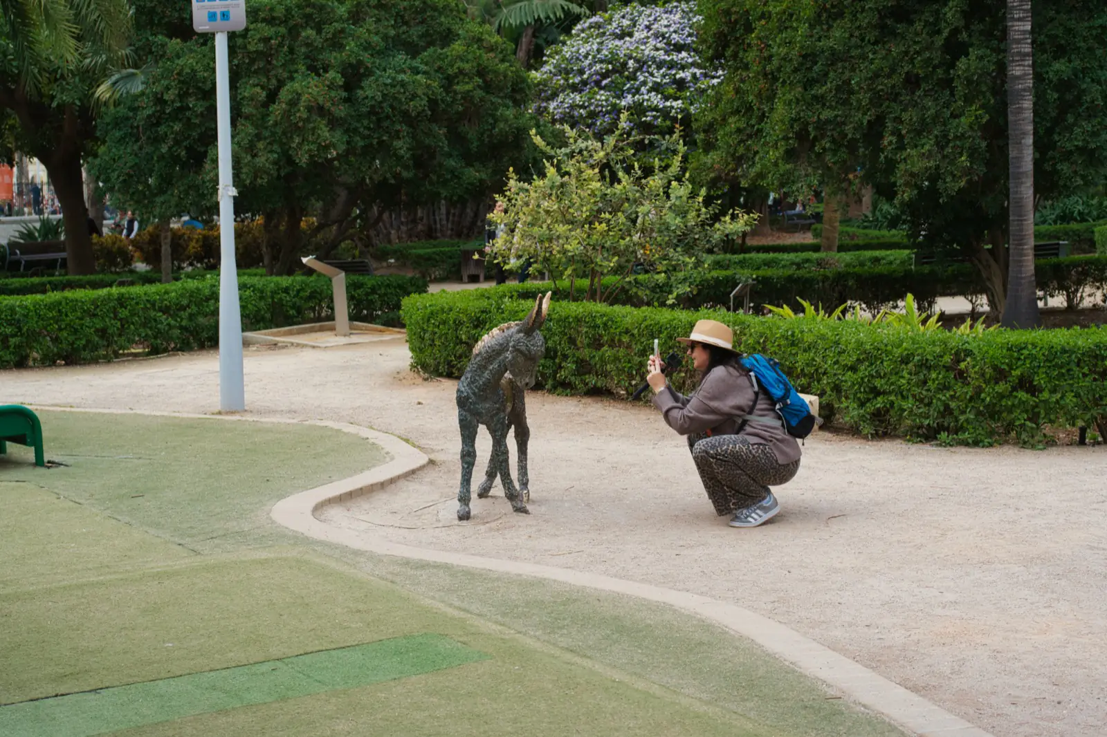 Heidi photographing the bronze Platero donkey statue in Parque de Málaga