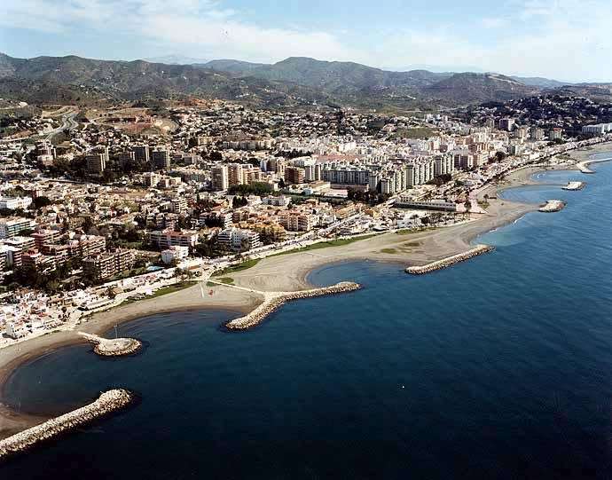 Pedregalejo beachfront with traditional fishing boats and low-rise buildings