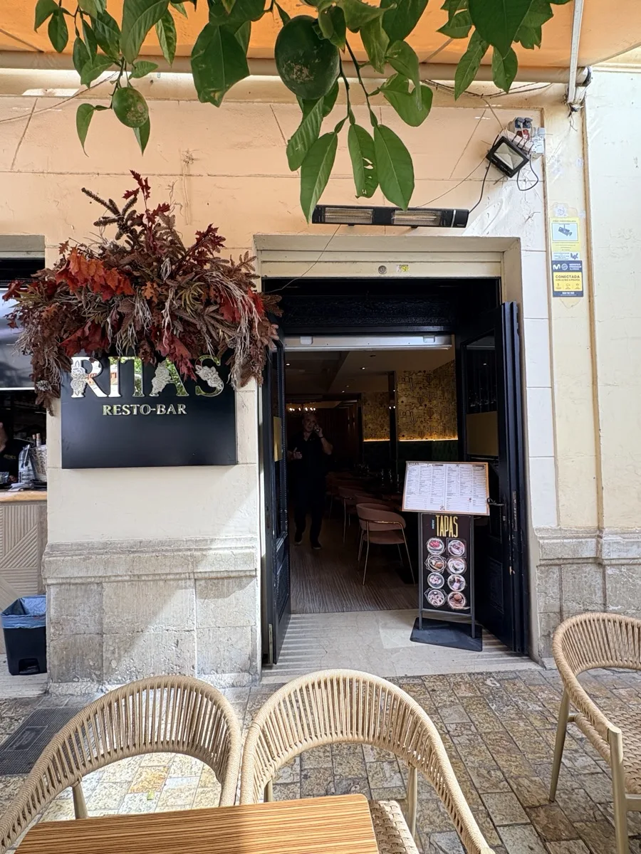 The Ritas Resto-Bar sign and entrance in Málaga, with the tapas board and menu stand by the door