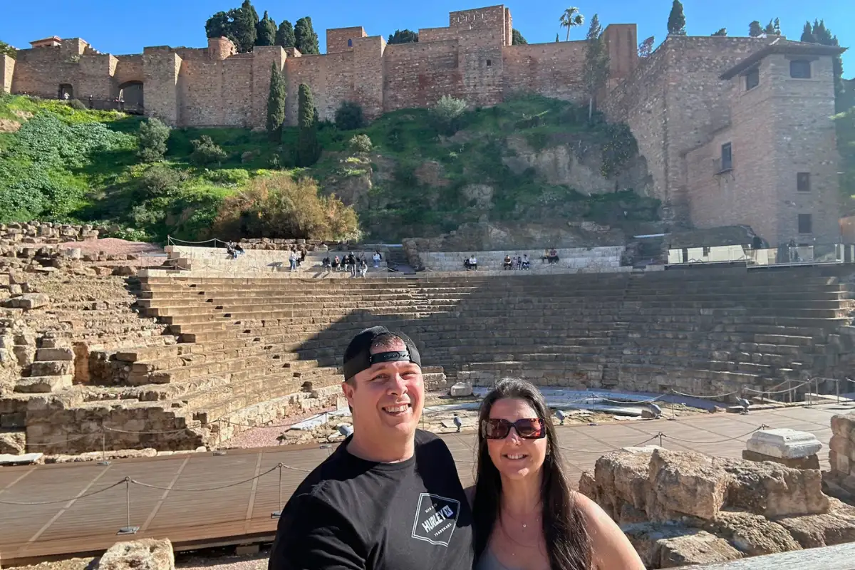 Couple at the Roman Theatre ruins in Málaga with the Alcazaba fortress on the hill behind