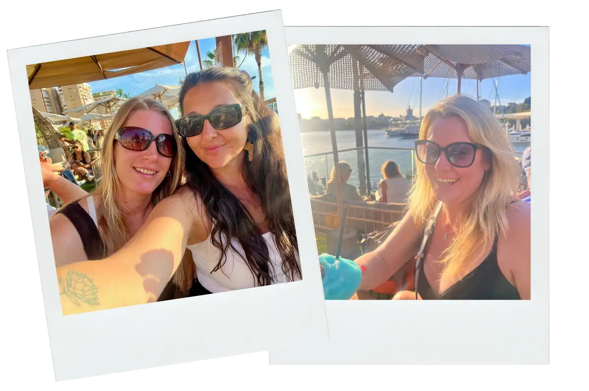 Two women with drinks watching the sunset from a rooftop terrace in Malaga