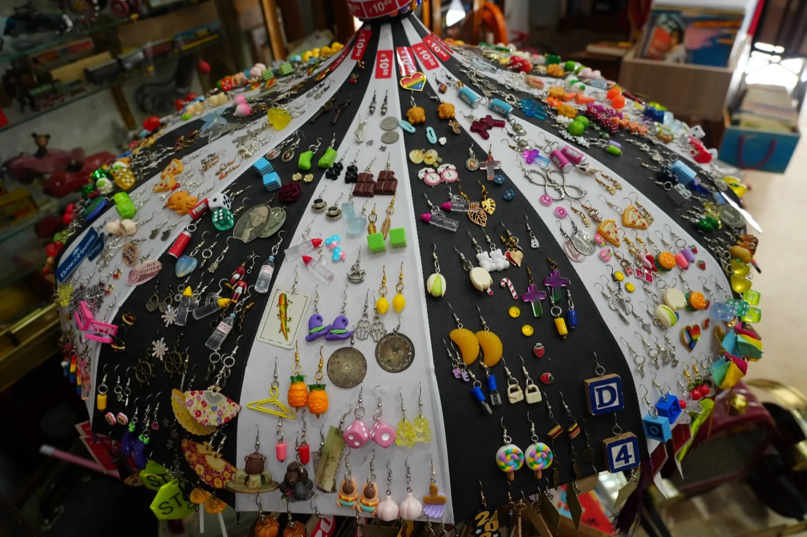 Open umbrella at Roto in Malaga covered in hundreds of pairs of novelty earrings poked through the fabric, including a chocolate bar pair