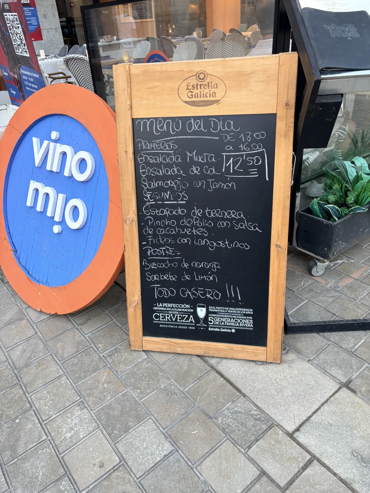 The chalkboard menú del día sign outside Vino Mio in Málaga, listing starters, mains and desserts for €12.50, served 1pm to 4pm