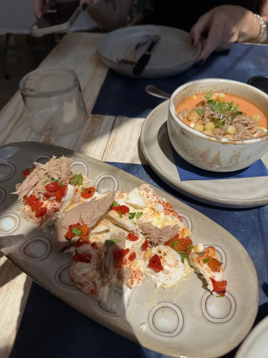 A starter of cold tomato soup topped with tuna and croutons, alongside a composed salad of tuna, egg and roasted peppers, part of the menú del día at Vino Mio in Málaga