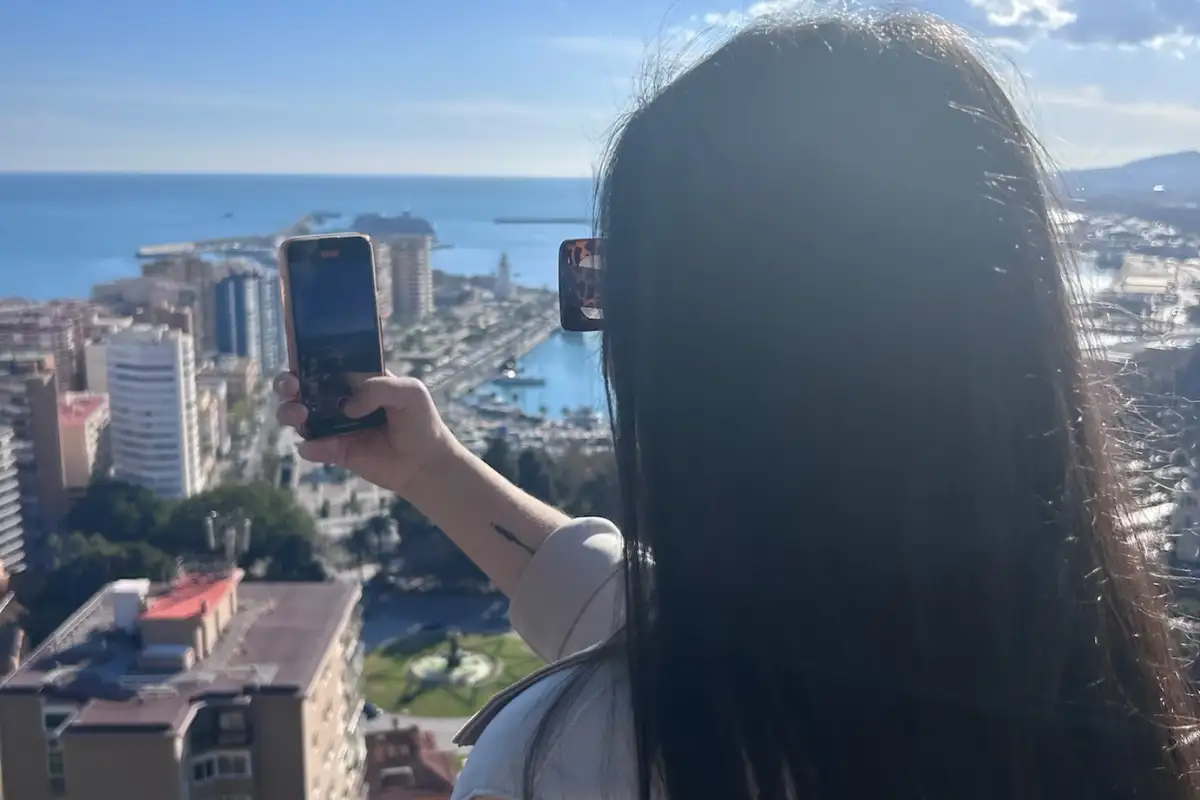 Visitor photographing the panoramic view over Málaga city and port from above