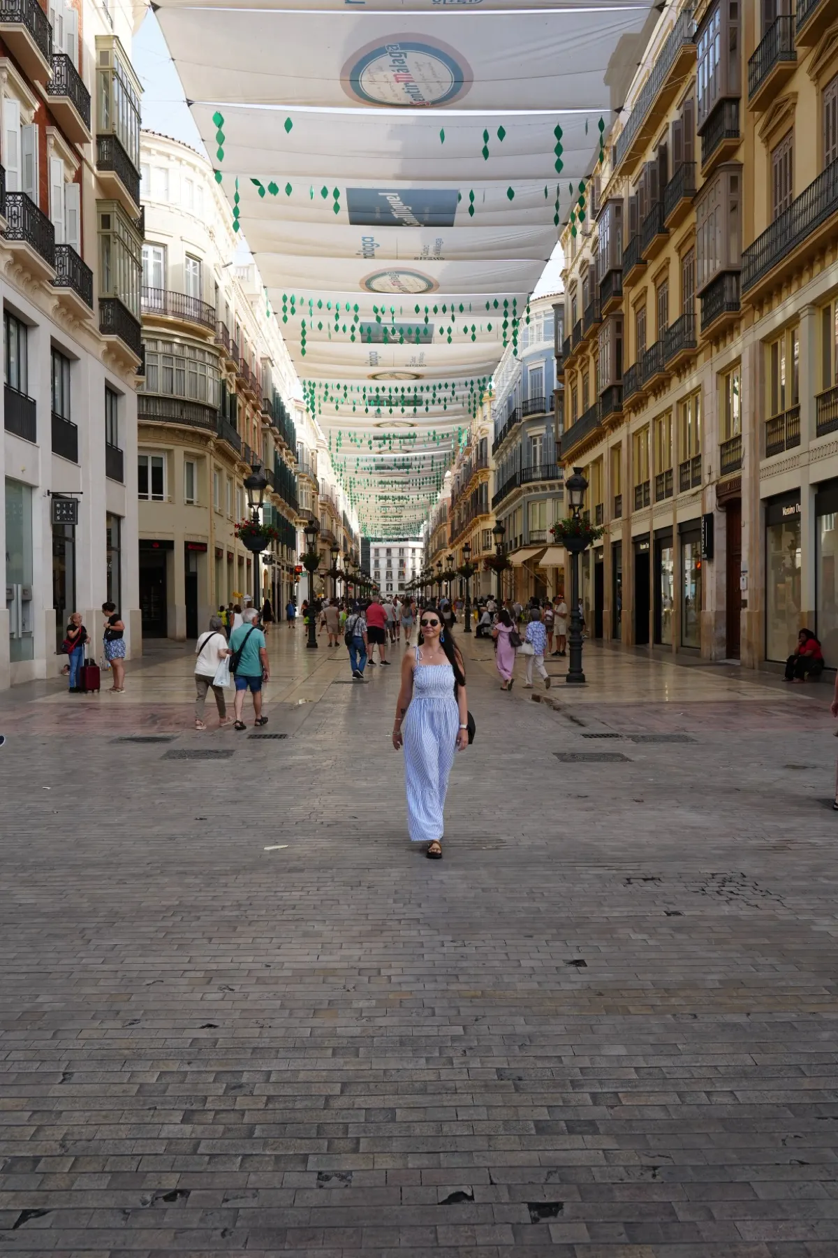 Heidi walking down Calle Larios under the white summer shade canopy