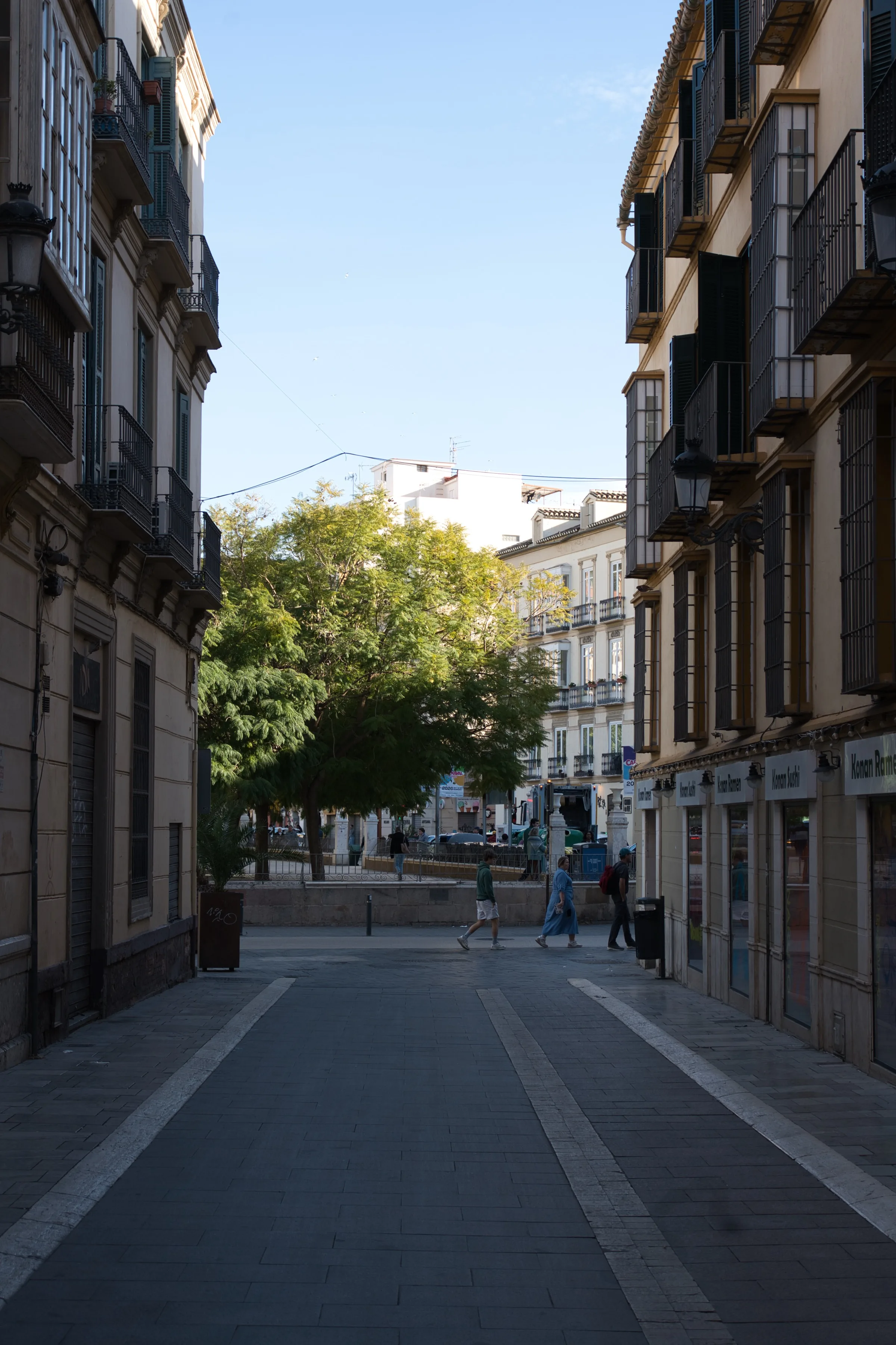 A quiet old-town pedestrian street in Málaga under clear winter skies