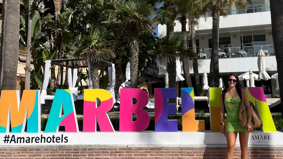 Woman posing in front of the colourful Marbella sign at Amare Beach Hotel