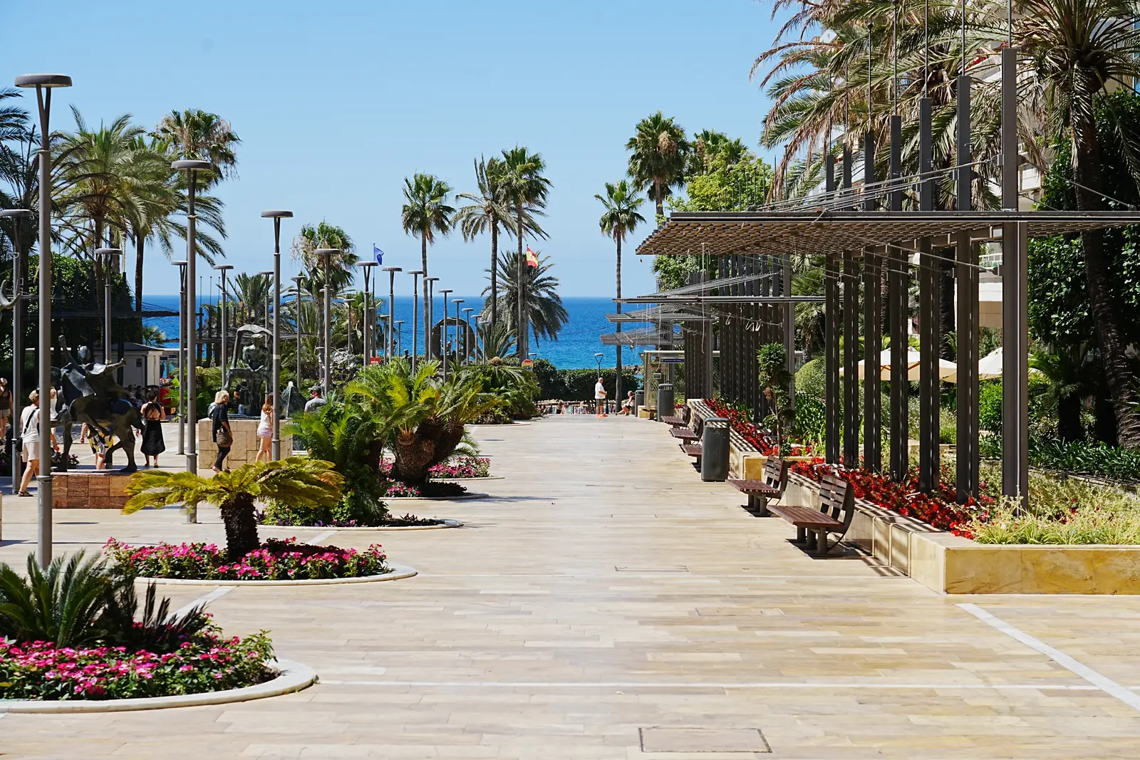 Palm-lined promenade in Marbella with the sea in the background