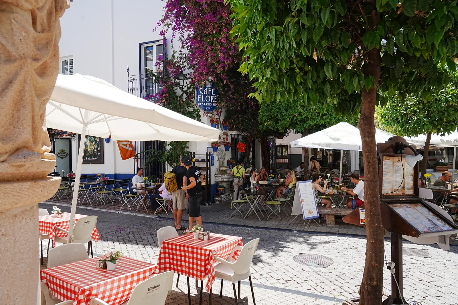 people sittding down at a cafe eating and drinking in marbella.