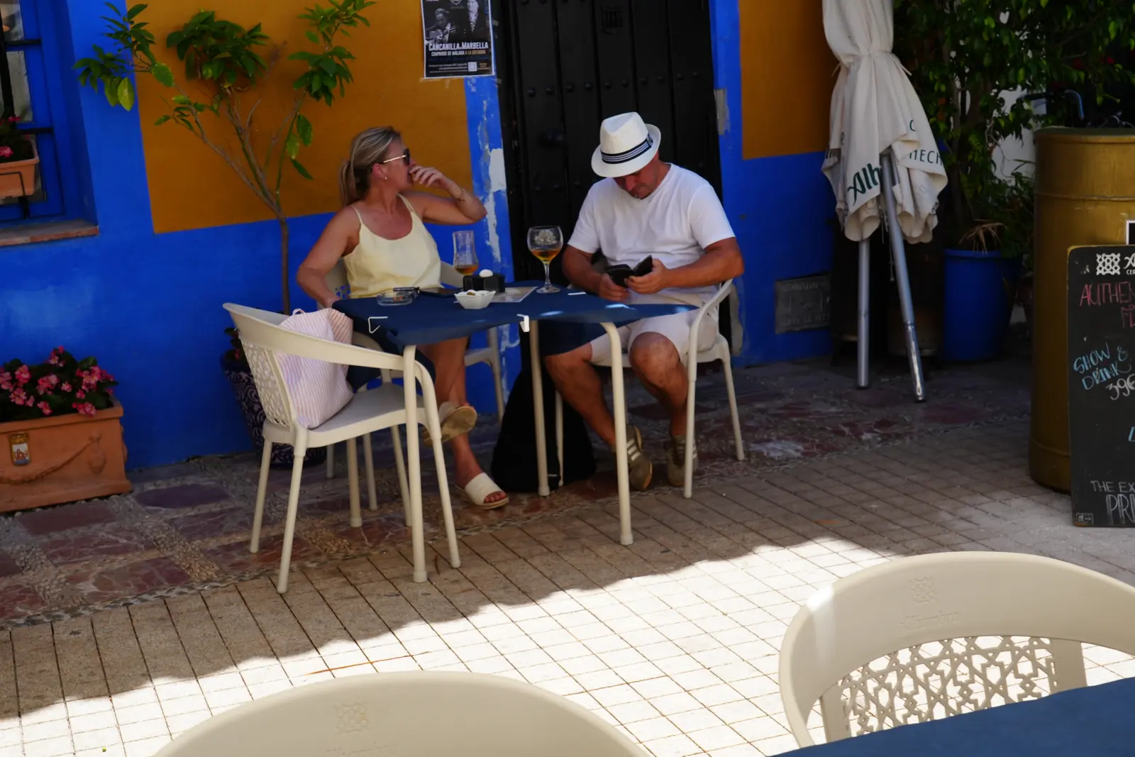 A couple sitting at a table enjoying drink in Marbella.