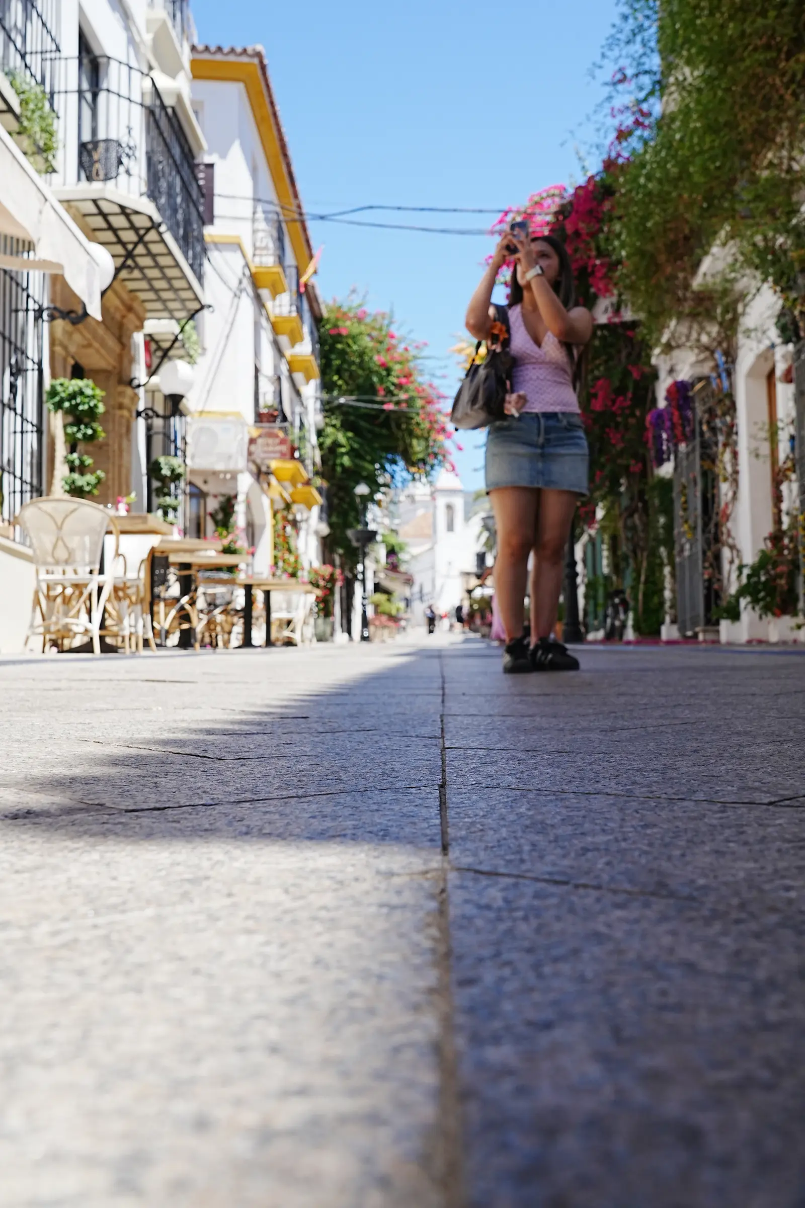 a woman talking a photo while talking the streets of marbella