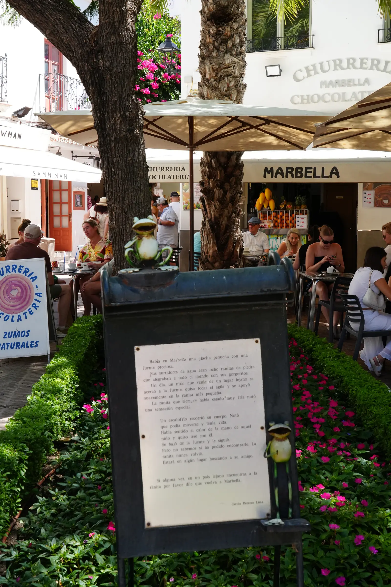The plaque telling the legend of the missing frog, with Churreria Marbella behind it