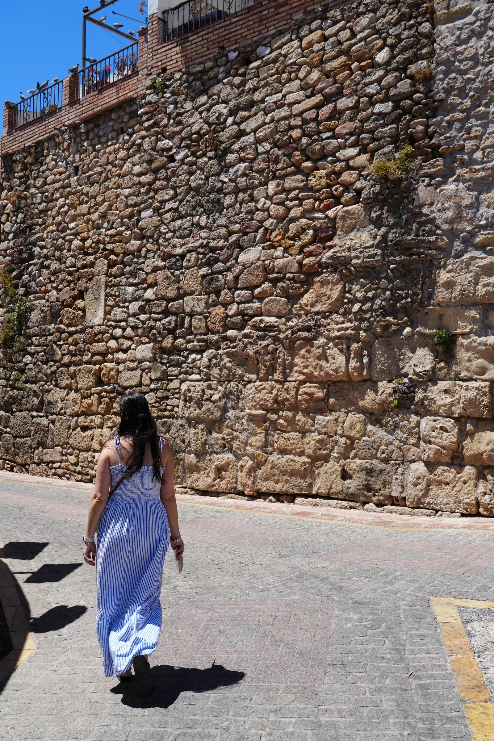 Woman beside the ancient Moorish castle walls in Marbella Old Town