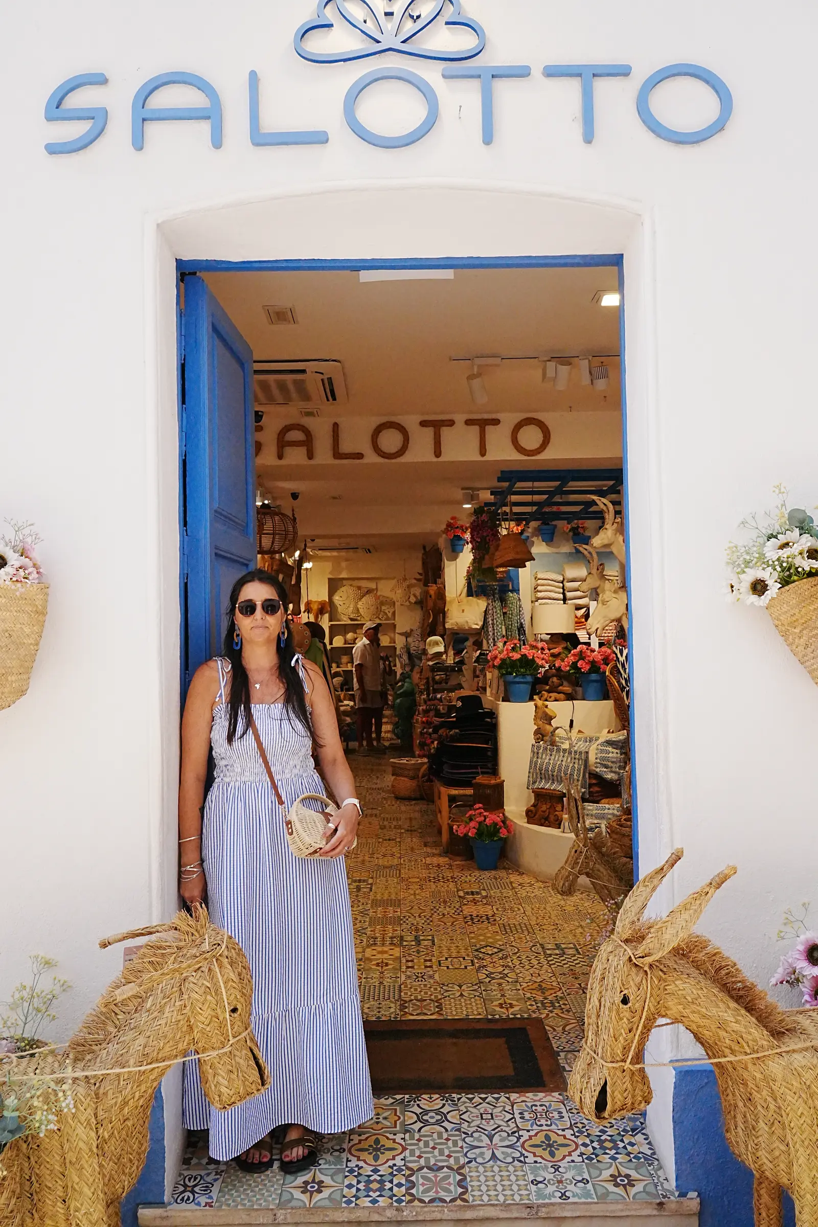 Woman browsing a Marbella Old Town boutique doorway with woven esparto goods