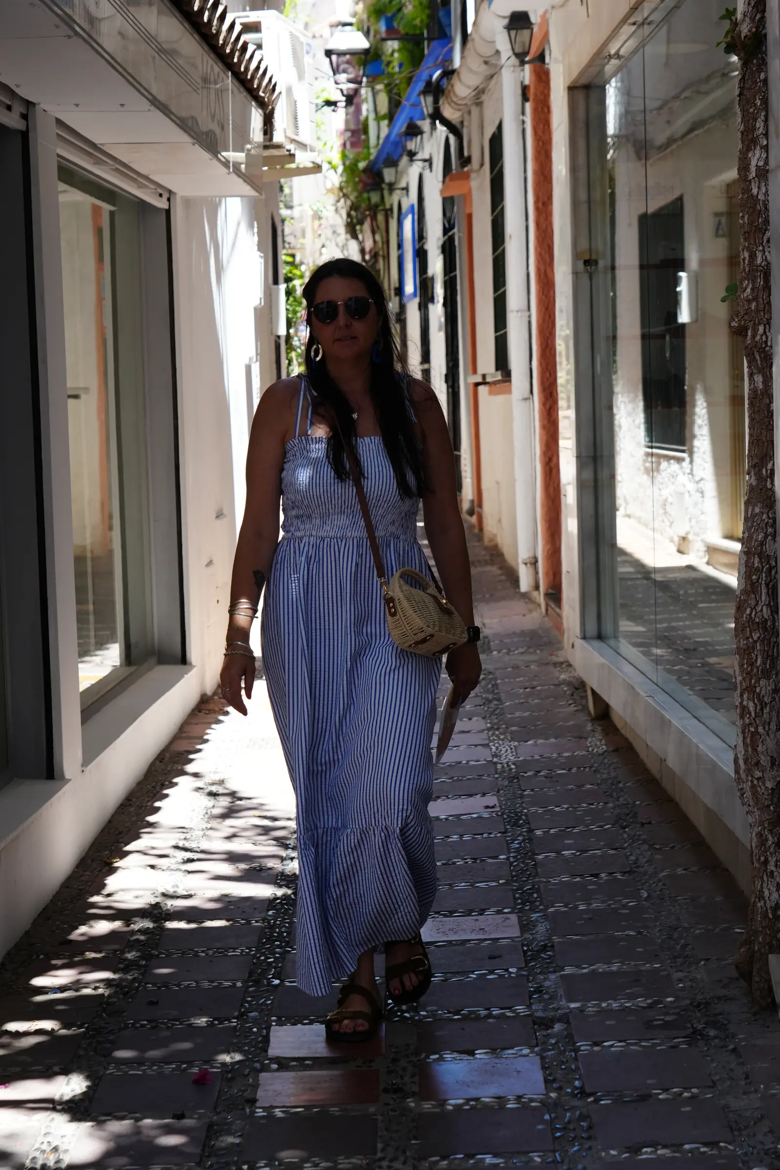 Heidi walking down a street that looks pretty plain in Marbella.