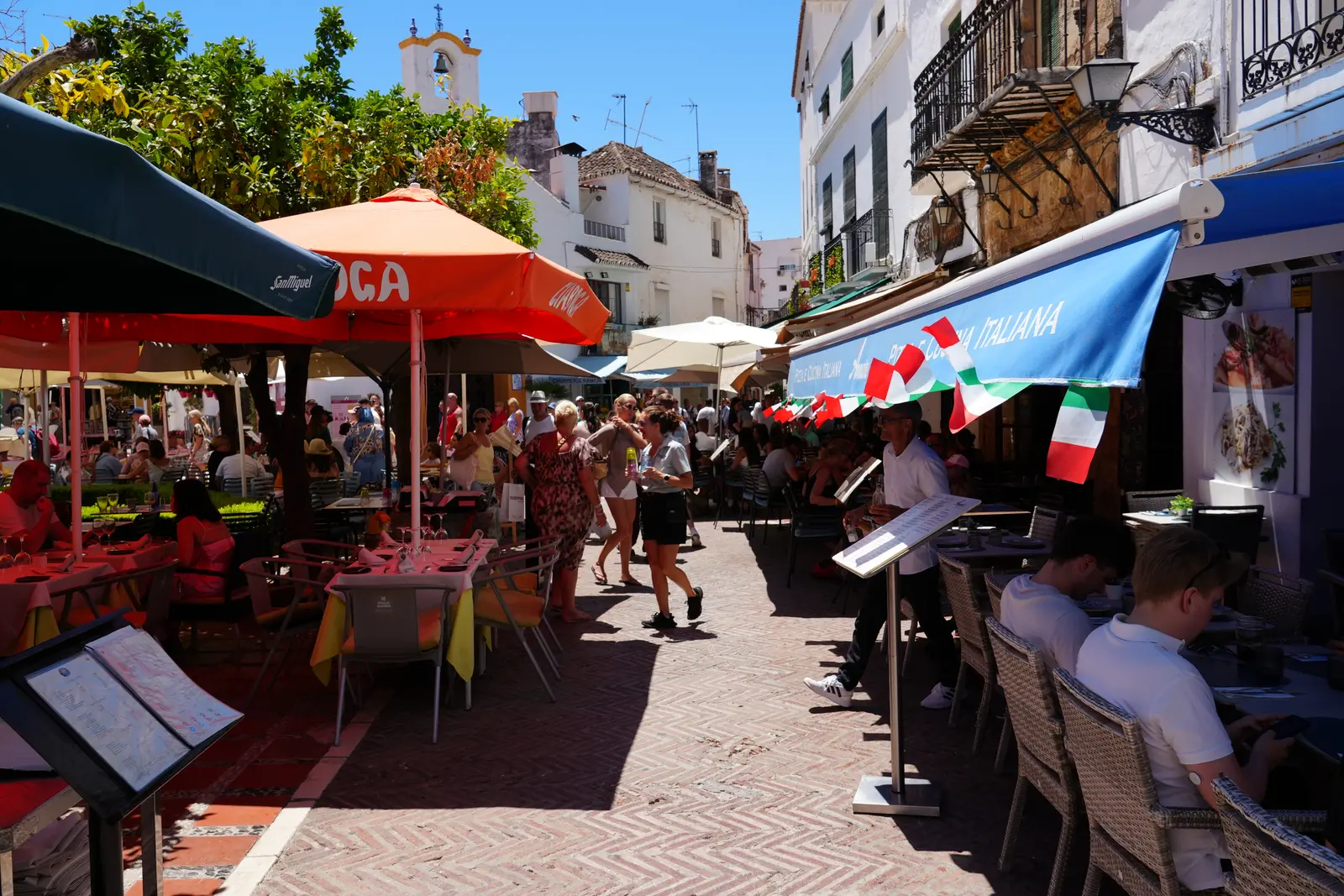 Cafe terraces and orange trees at Plaza de los Naranjos in Marbella Old Town