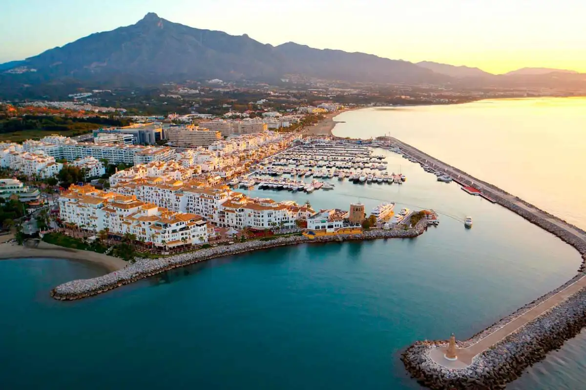 Aerial view of Puerto Banús marina at sunset with yachts and La Concha mountain behind