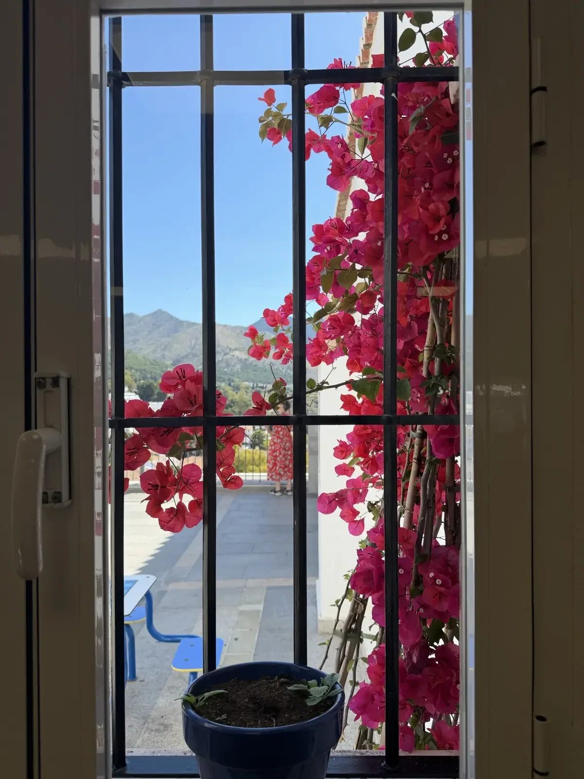 Bougainvillea framing a window overlooking the whitewashed rooftops of Mijas Pueblo