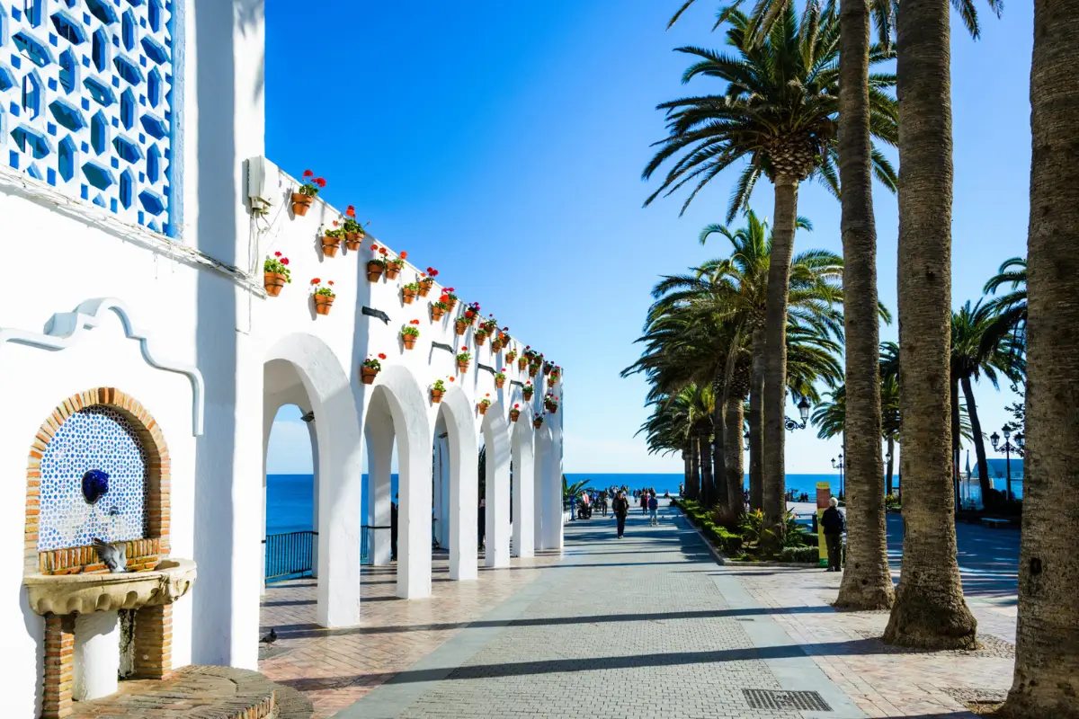 White arched colonnade with flower pots along the Balcón de Europa in Nerja old town