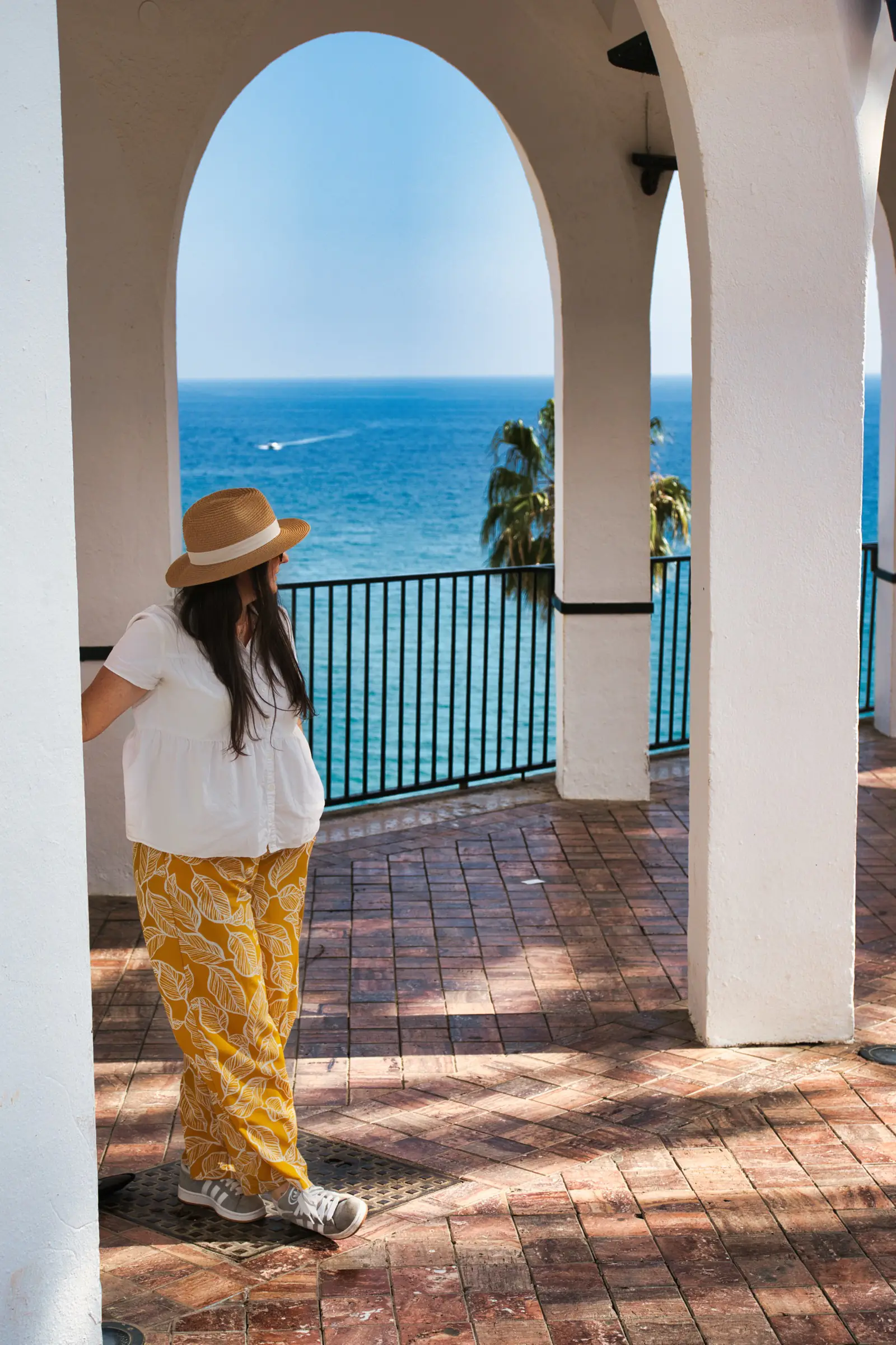 A woman enjoying the view at the Nerja white arches in Nerja.