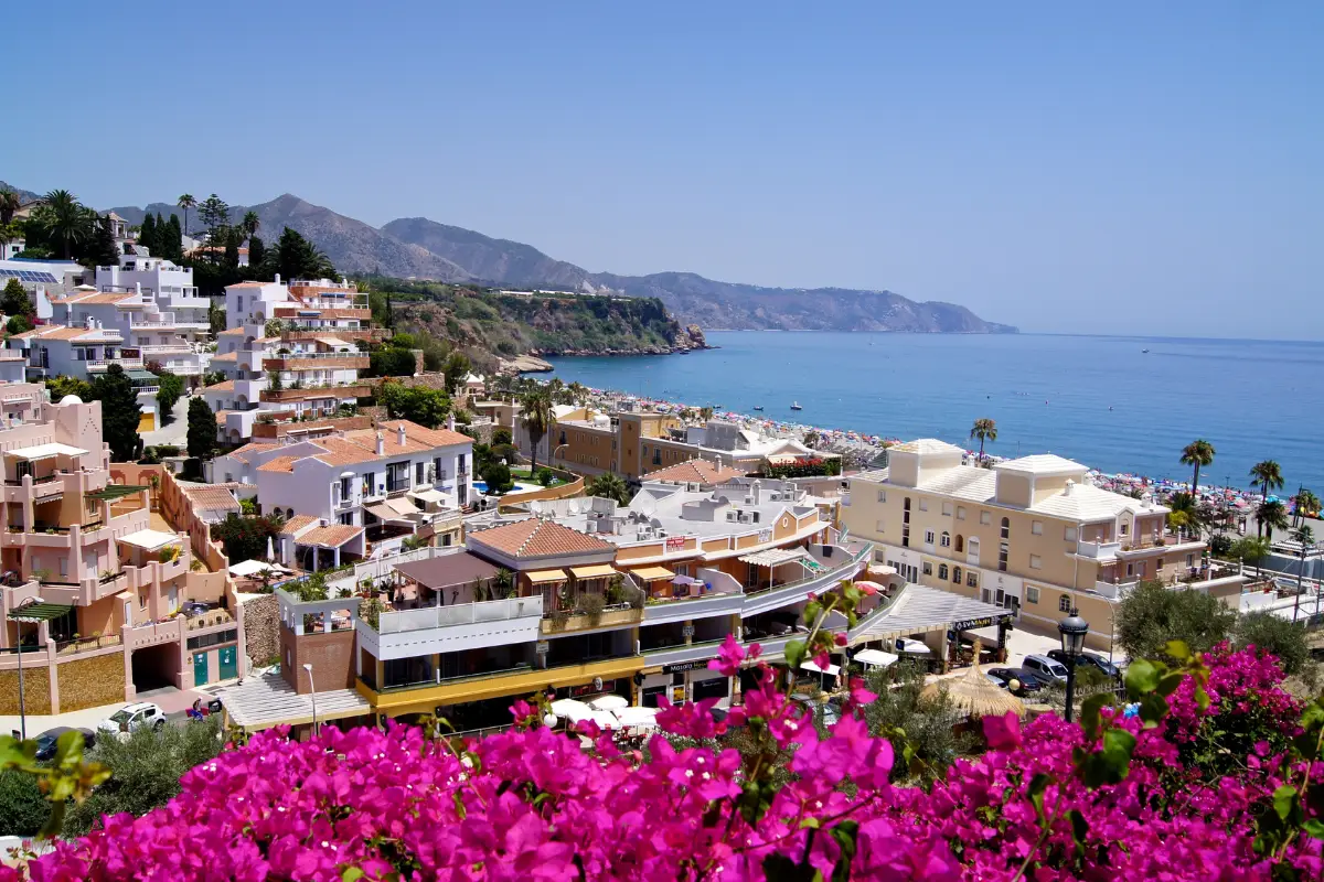 Panoramic view of Nerja and its beaches with bougainvillea in the foreground
