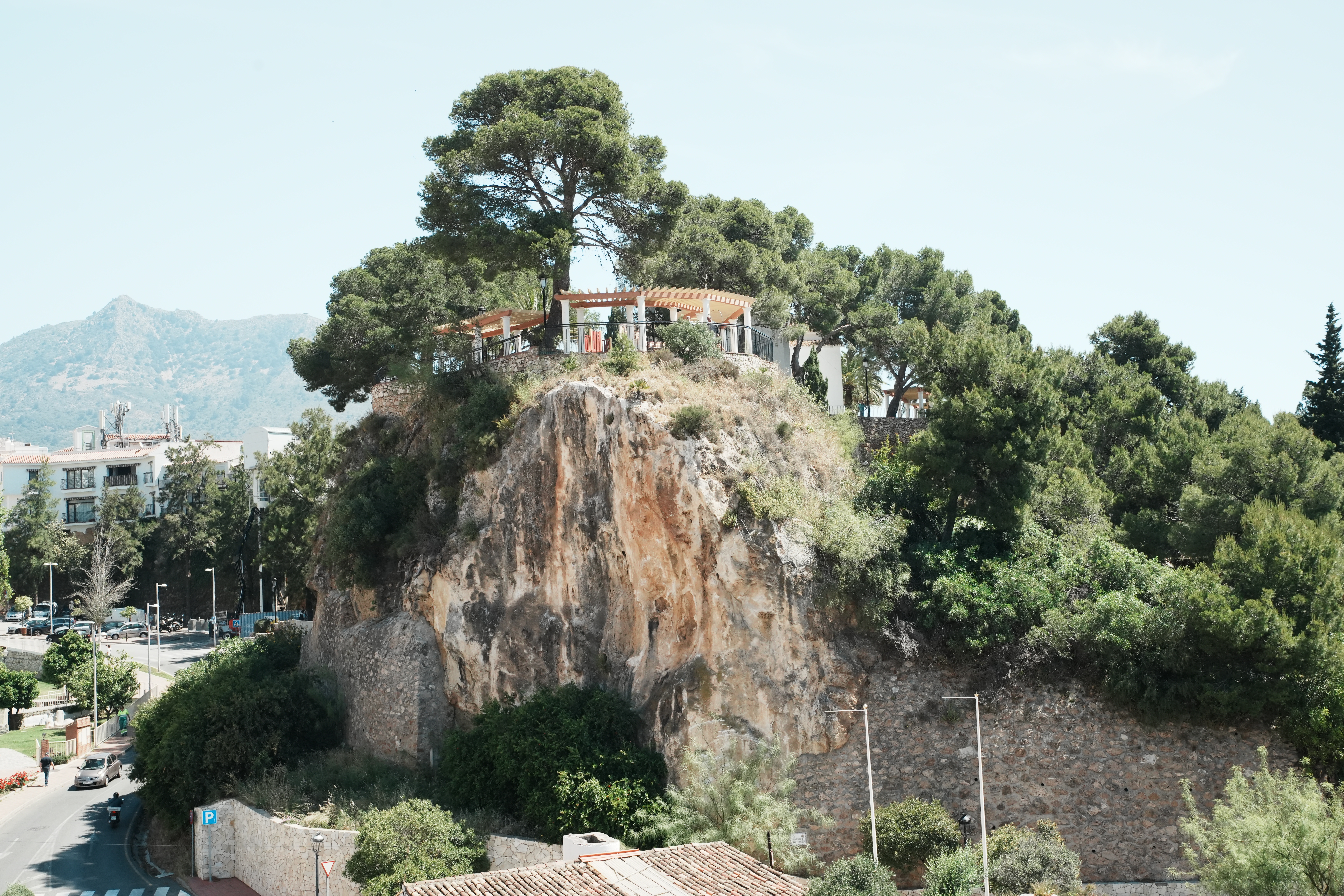 Rocky outcrop topped with a viewpoint terrace in Benalmadena Pueblo, mountains behind
