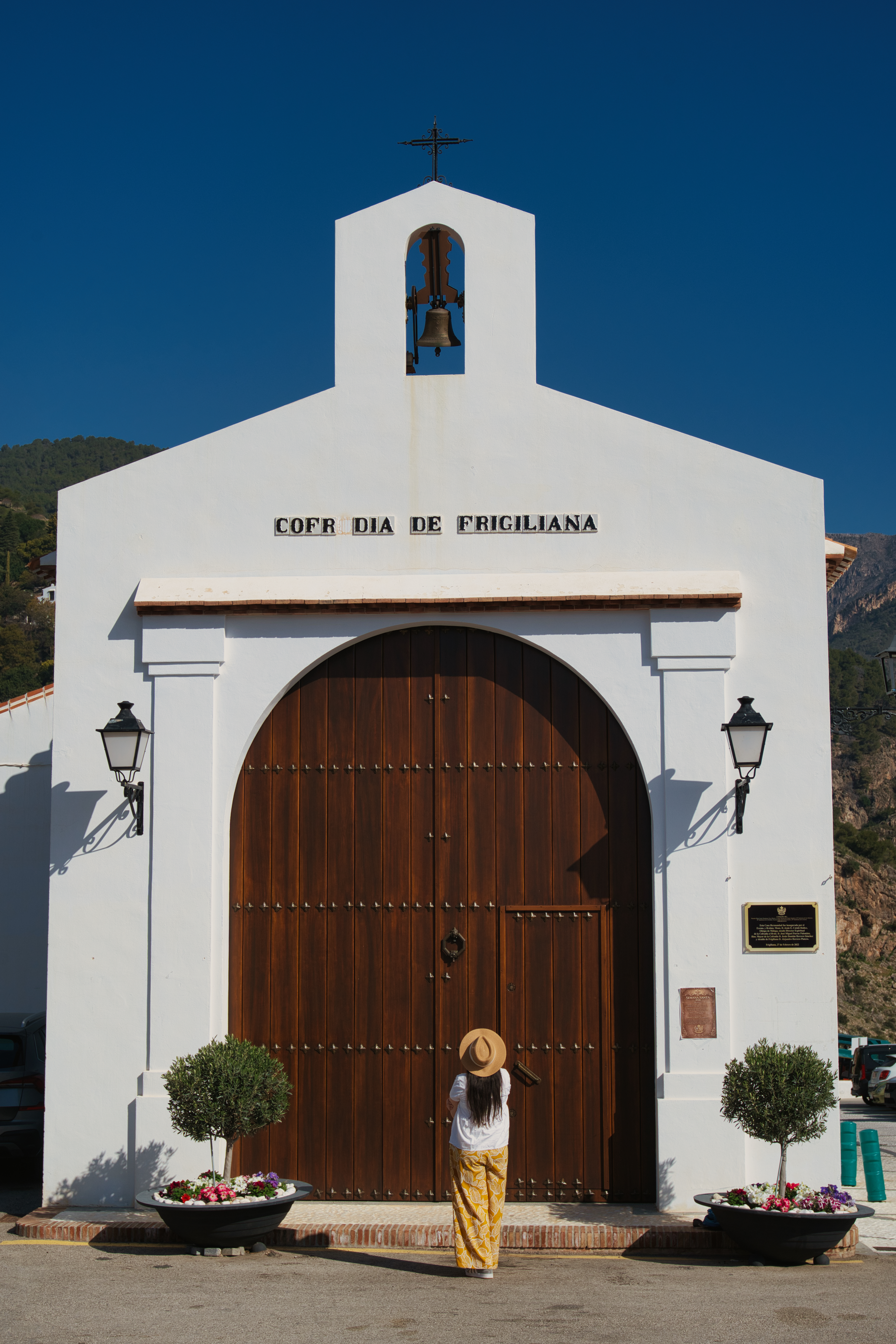 The white facade of the Cofradia de Frigiliana chapel, with its bell tower